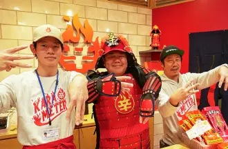 辛メーターポーズをする三人。左から店長・野口くん、辛メーターのオリジナル甲冑を着たゴリけんさん、辛メーター代表の江口カン。